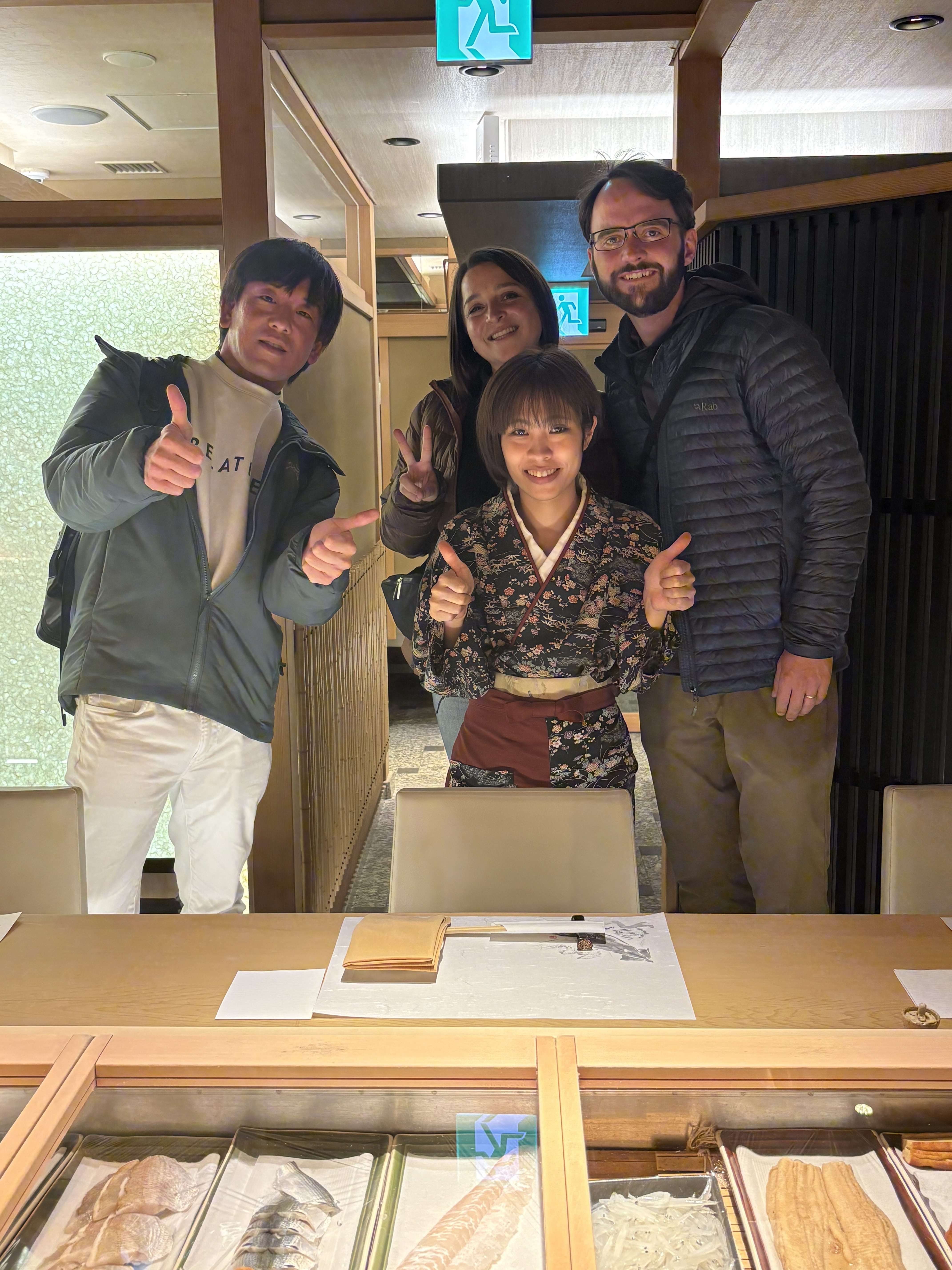 Happy international guests with kimono-clad host at premium sushi restaurant in Tokyo with private tour guide Mao