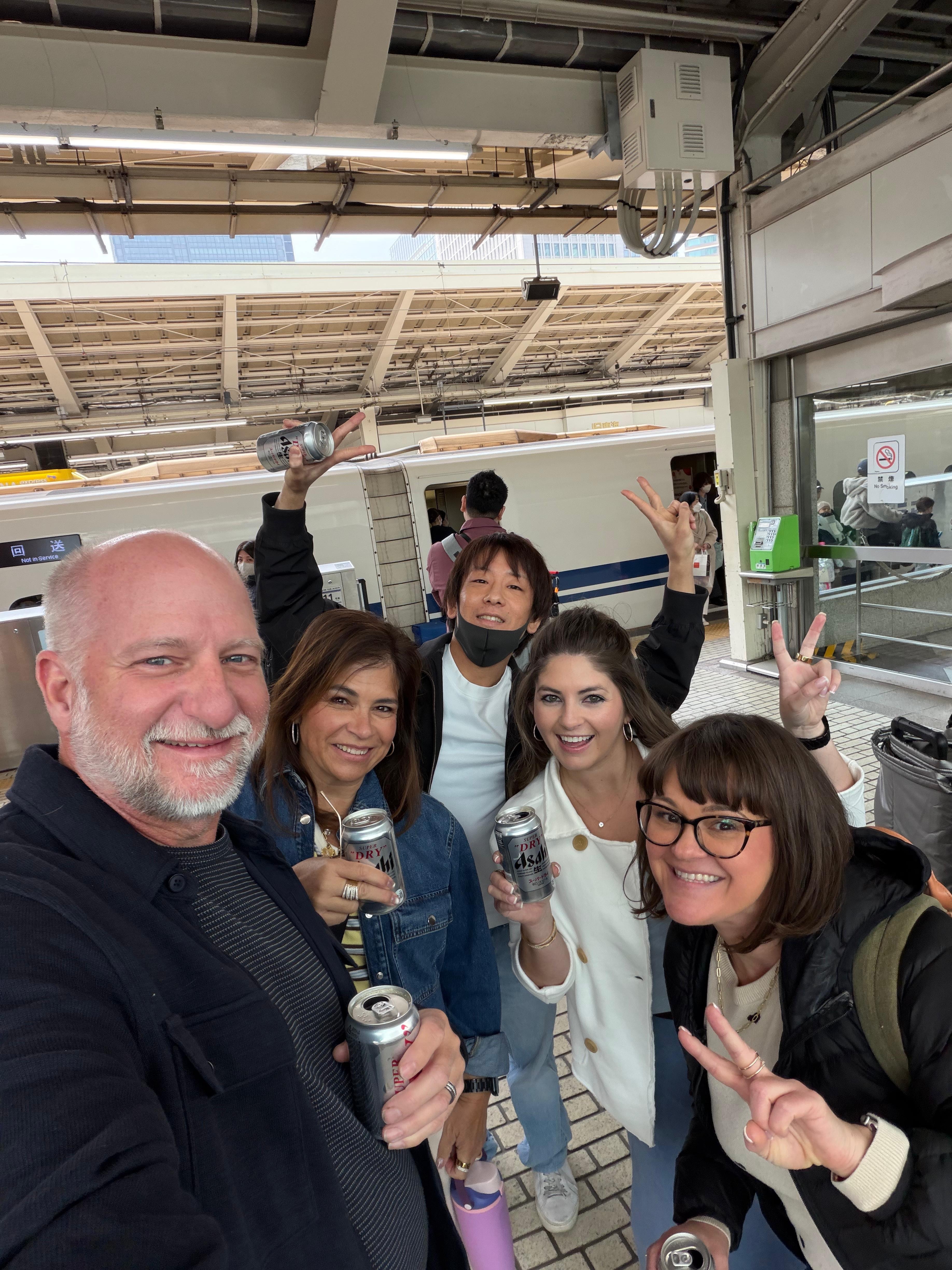 Tour group celebrating with drinks at Tokyo Shinkansen station with private guide